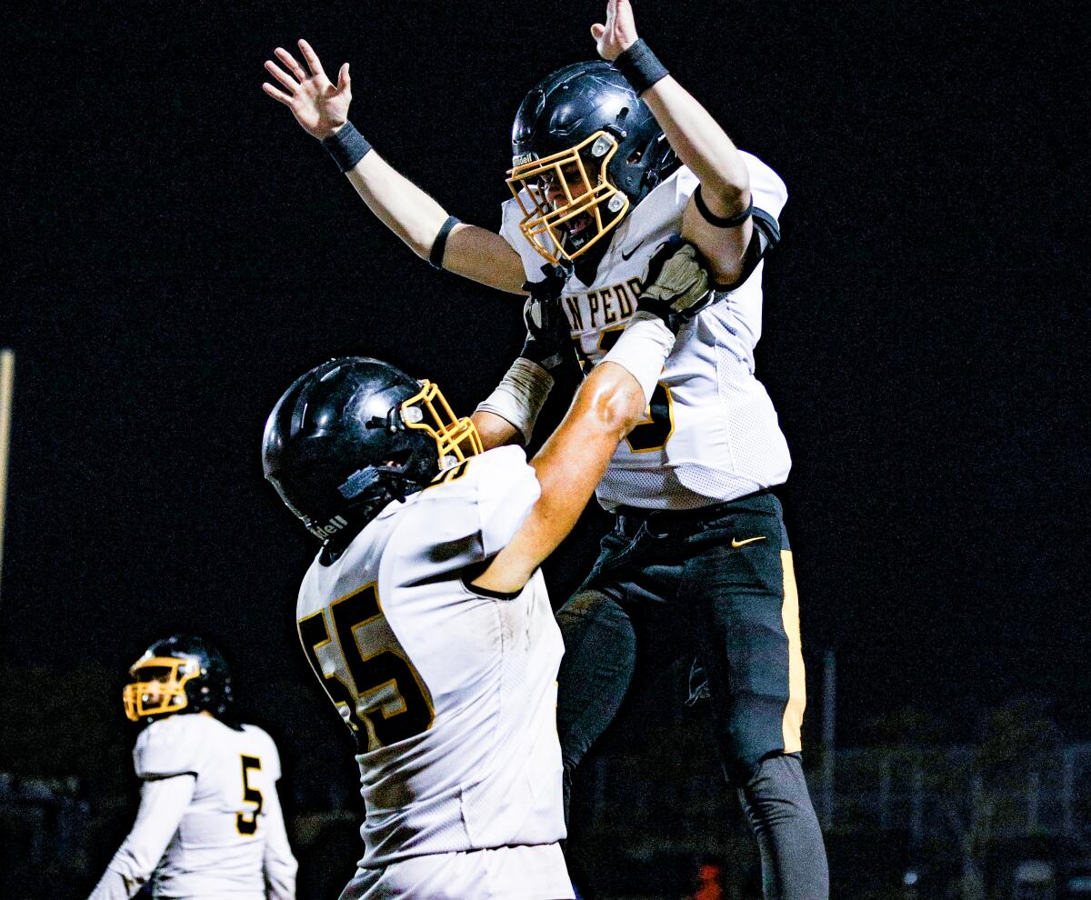 San Pedro's Adrian Aldamo lifts up Santiago Rivera after Rivera's touchdown against Garfield.