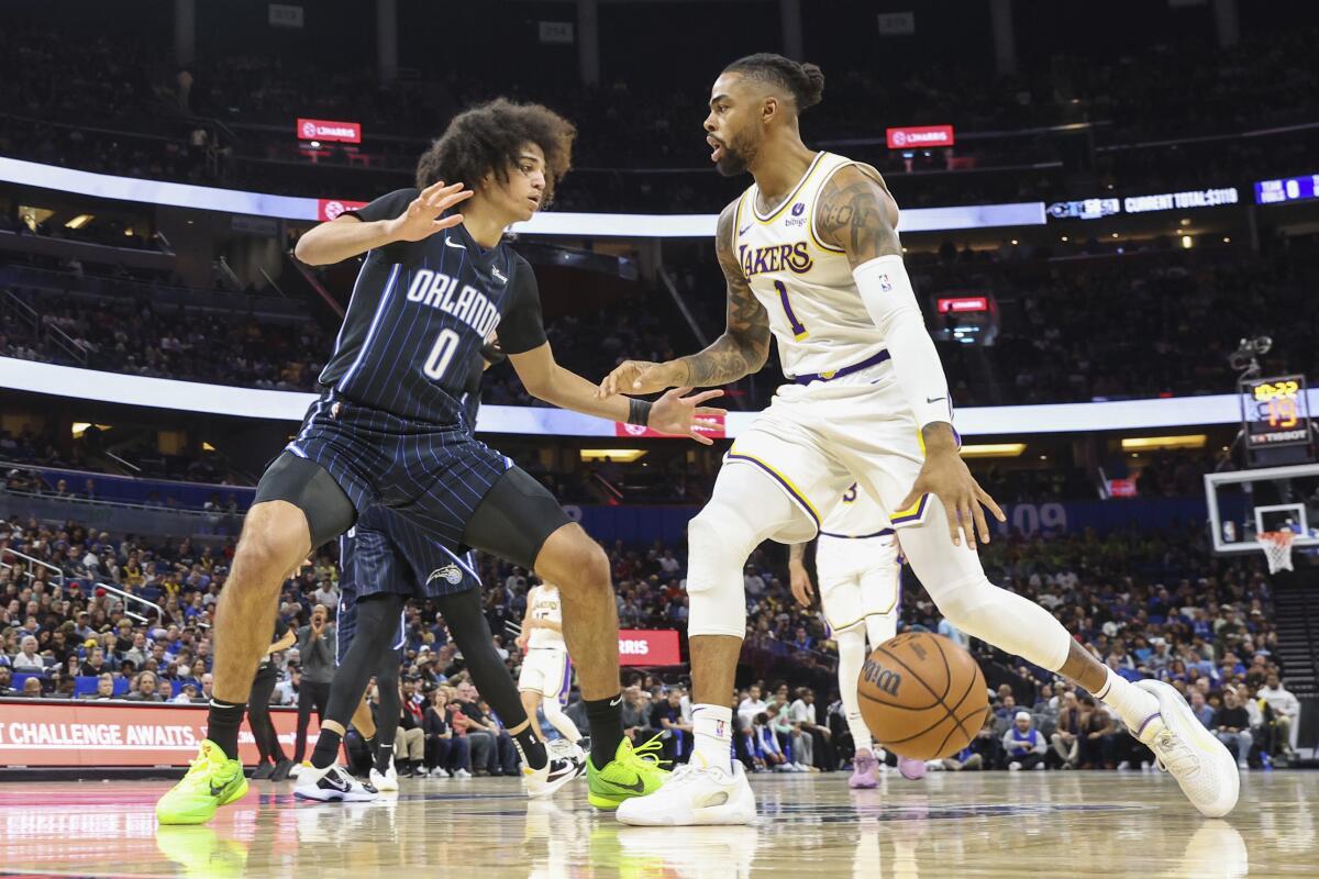 Magic guard Anthony Black, left, tries to cut off a drive by Lakers guard D'Angelo Russell.