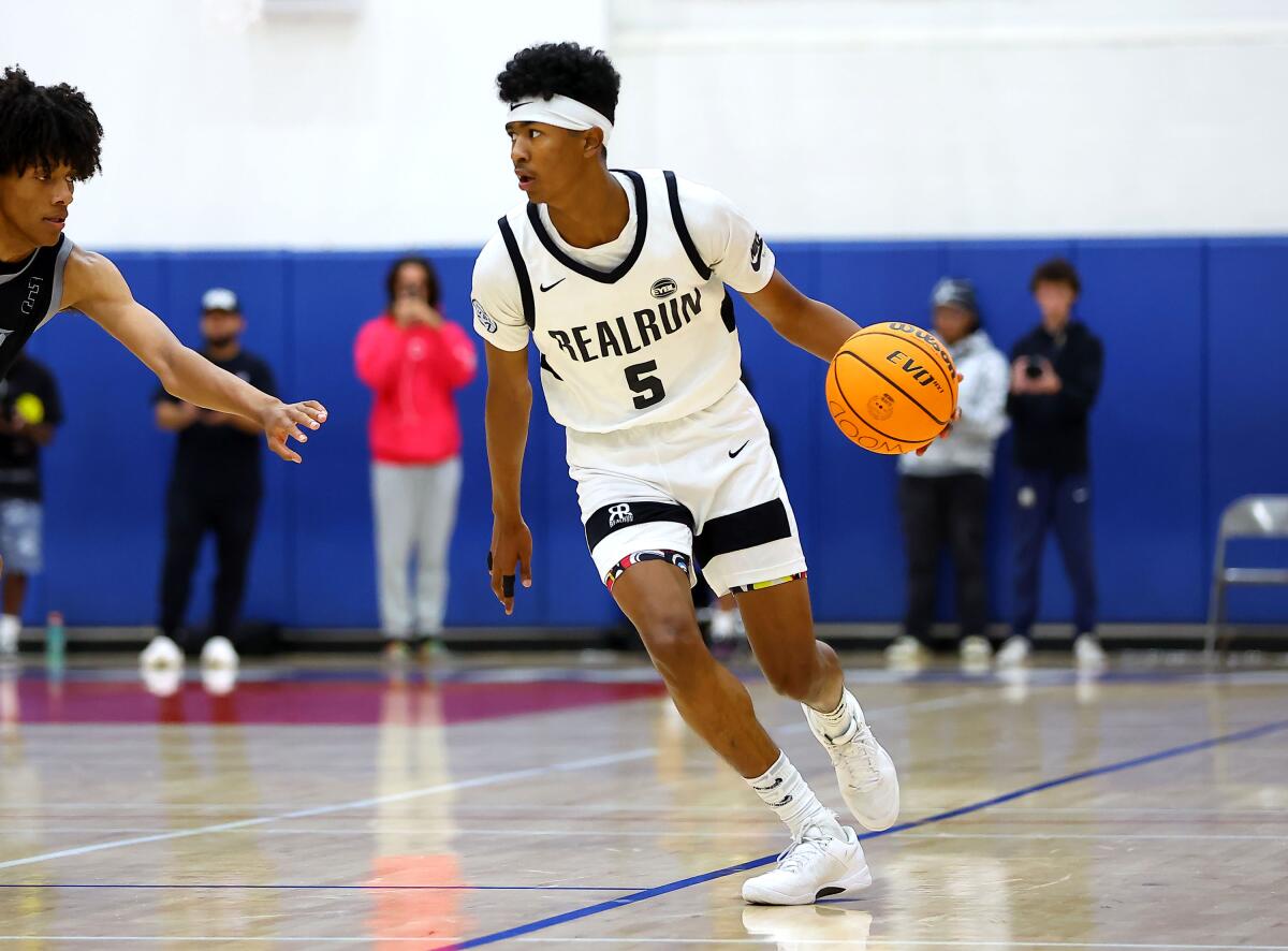 Lynwood sophomore Jason Crowe Jr. dribbles past a defender while bringing the ball up the court.