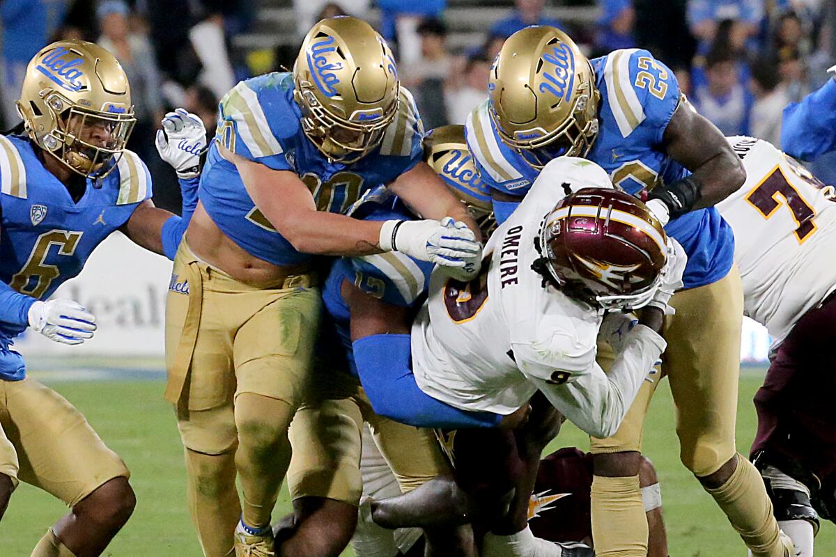 Pasadena, CA - THe UCLA defense puts the clamps on ASU wide receiver Troy Omeire.