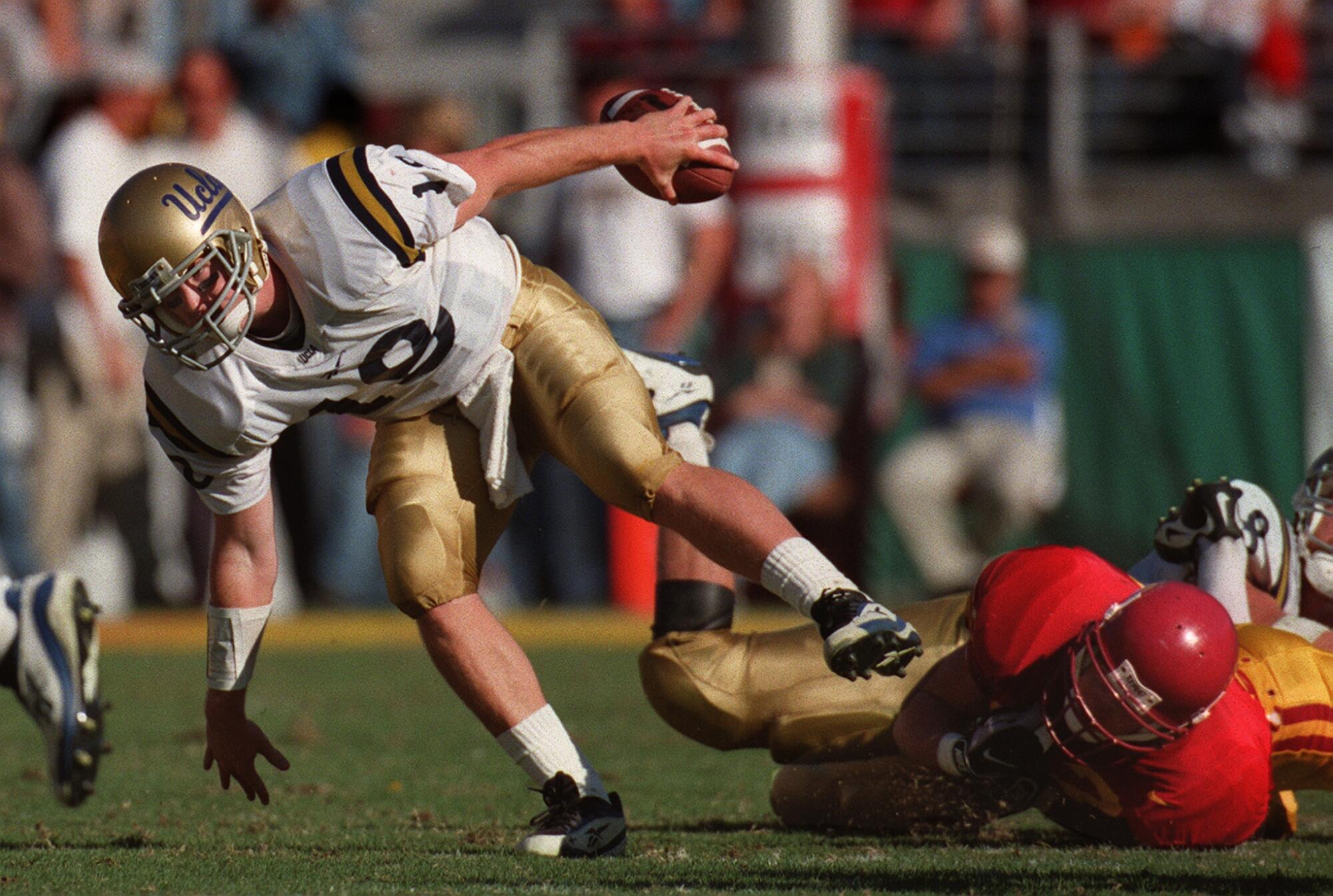 UCLA quarterback Cade McNown hands off to running back Skip Hicks during a 1997 game against rival USC.