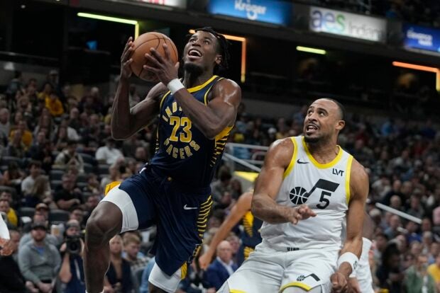 Indiana Pacers' Aaron Nesmith (23) puts up a shot against Utah Jazz's Talen Horton-Tucker (5) during the first half of an NBA basketball game, Wednesday, Nov. 8, 2023, in Indianapolis.