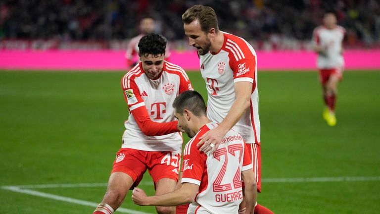 Bayern&#39;s Raphael Guerreiro, bottom, celebrates with his teammate Harry Kane